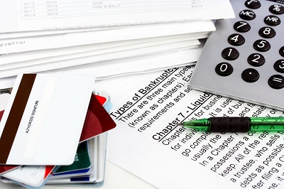 Bankruptcy Document With Bills, Credit Cards, Calculator And Pen