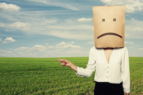 sad woman pointing at something over green field